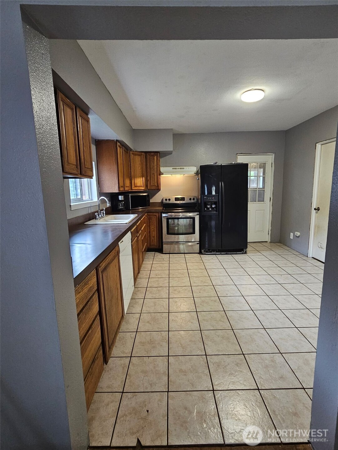 906 Southwest Mayer Street Winlock, WA 98596 - Photo 8 of 16 a large kitchen with a stove a sink dishwasher and a refrigerator