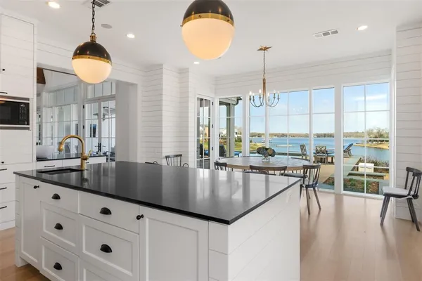 a kitchen with center island chandelier and living room view