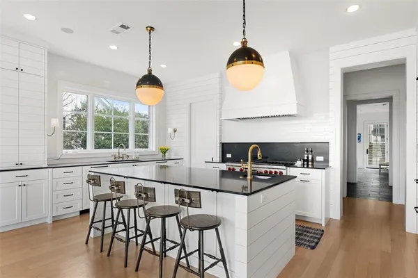 a kitchen with a table chairs stove and wooden floor
