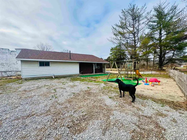 a view of house with backyard and outdoor seating
