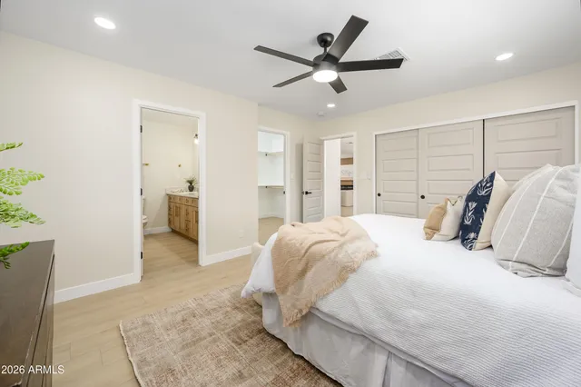 a spacious bedroom with a bed and a ceiling fan