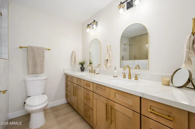 a bathroom with a double vanity sink mirror and toilet