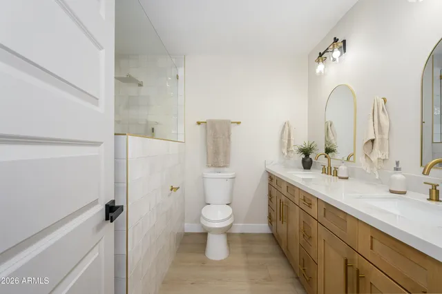 a bathroom with a double vanity sink toilet and shower