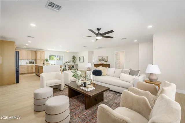 a living room with furniture a rug and kitchen view