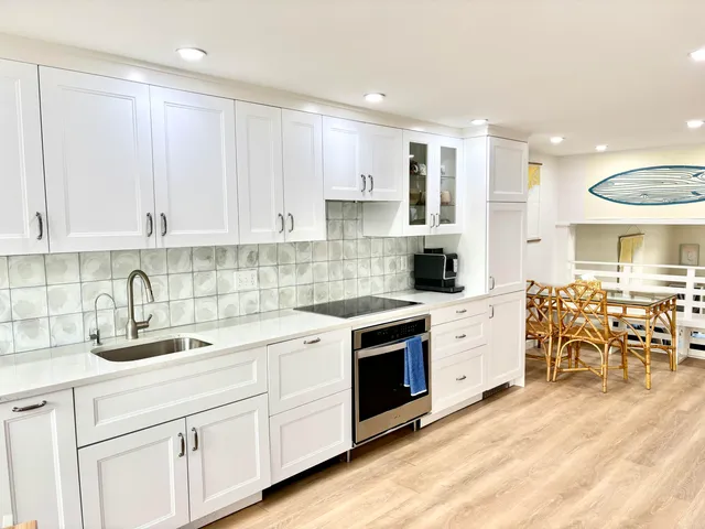 a kitchen with granite countertop a sink stove and cabinets