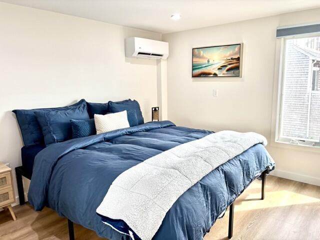 500 Ocean Street, Unit 147 Hyannis, MA 02601 - Photo 8 of 23 a bedroom with a bed two painting on the wall and a large window