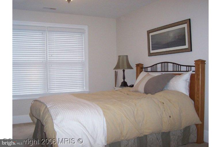 4416 Ridge Street Chevy Chase, MD 20815 - Photo 15 of 20 a bedroom with a bed and a painting on the wall