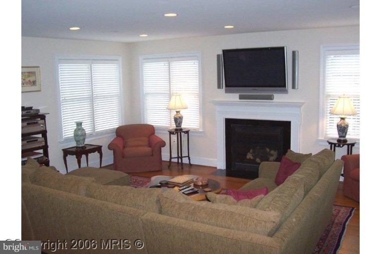 4416 Ridge Street Chevy Chase, MD 20815 - Photo 6 of 20 a living room with furniture a fireplace and a flat screen tv