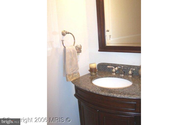 4416 Ridge Street Chevy Chase, MD 20815 - Photo 7 of 20 a bathroom with a granite countertop sink and a mirror