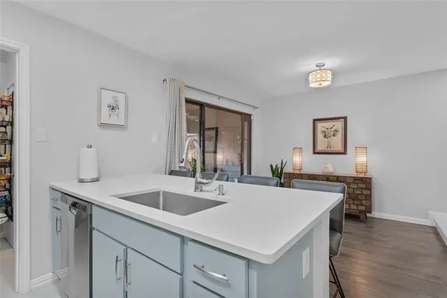 a kitchen with a sink a counter and chairs