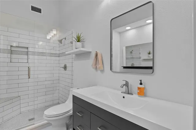 a bathroom with a sink a toilet and mirror