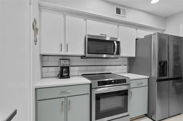 a kitchen with cabinets stainless steel appliances and a counter space
