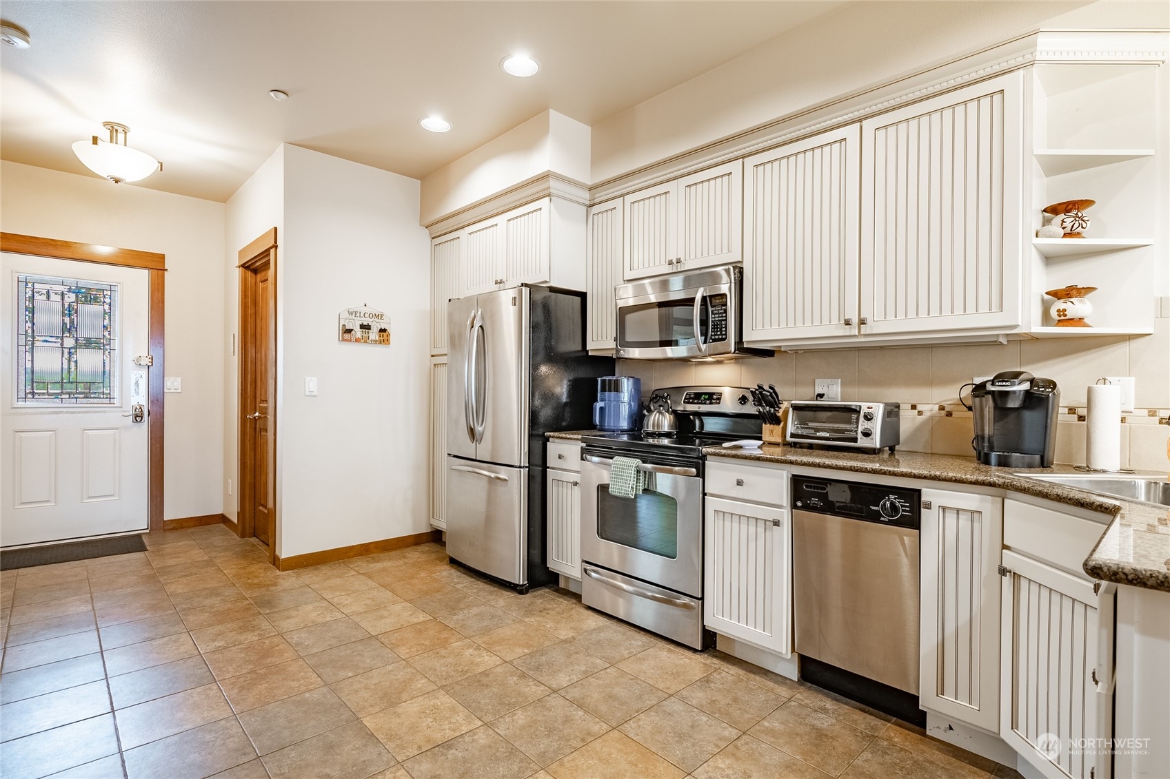 7714 Birch Bay Drive, Unit 203 Blaine, WA 98230 - Photo 10 of 25 a kitchen with stainless steel appliances granite countertop a stove a sink and a refrigerator