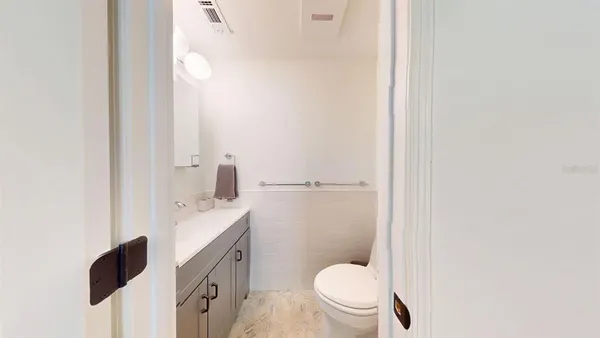 a bathroom with a granite countertop toilet and a sink
