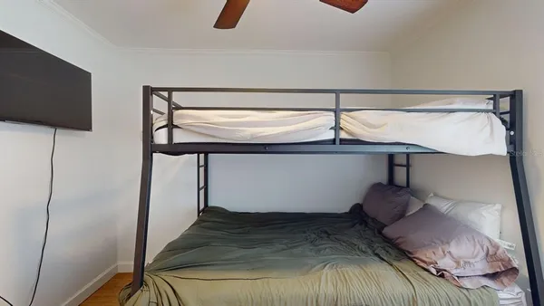 a bedroom with a bed and a flat tv screen on the table