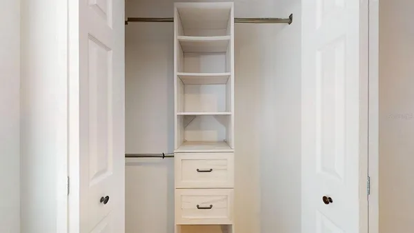 a view of walk in closet with empty racks