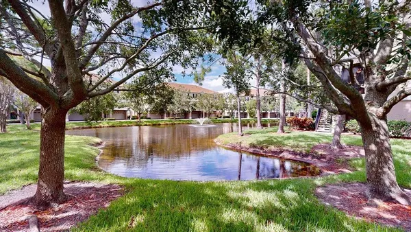 an aerial view of lake and residential houses with outdoor space