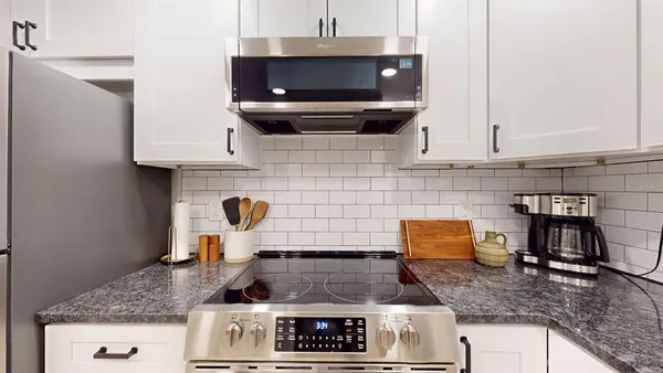 a kitchen with granite countertop a stove and a sink