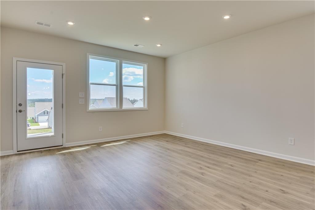 3280 Croftside Commons Powder Springs, GA 30127 - Photo 19 of 31 an empty room with wooden floor and windows