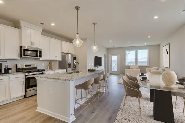 a large kitchen with kitchen island a island a sink a stove and a center island
