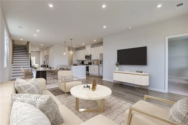 a living room with furniture kitchen view and a flat screen tv