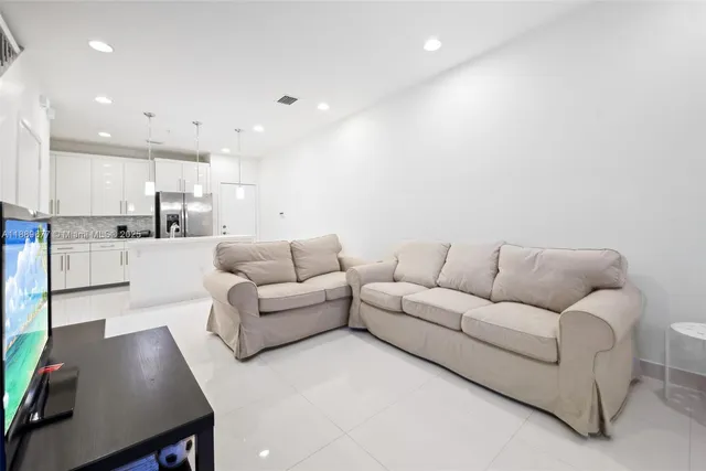 a living room with furniture and kitchen view