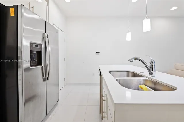 a kitchen with stainless steel appliances granite countertop a sink a refrigerator and a sink