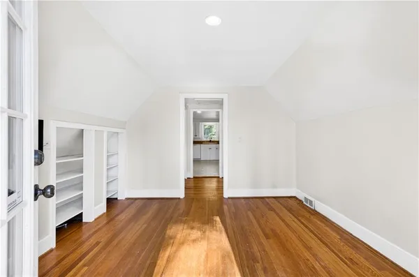 an empty room with wooden floor and closet