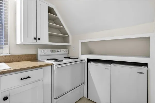 a kitchen with white cabinets and white appliances