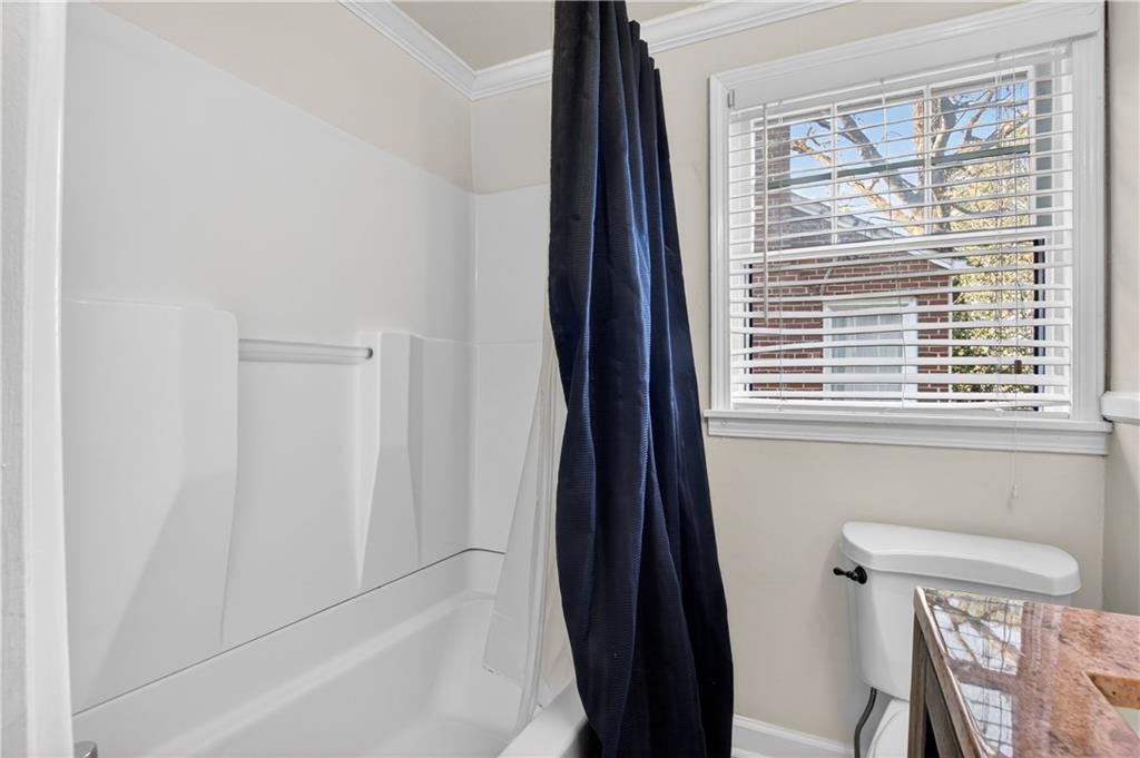 613 Pelham Road Northeast Atlanta, GA 30324 - Photo 7 of 24 a bathroom with a bathtub and a window