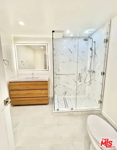 a bathroom with a glass shower door and a sink