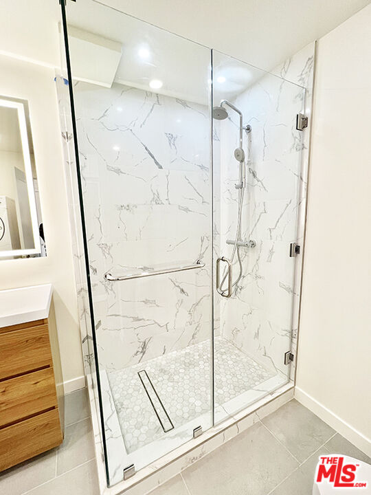 468 South Roxbury Drive, Unit PH Beverly Hills, CA 90212 - Photo 15 of 18 a bathroom with a glass shower door and a sink