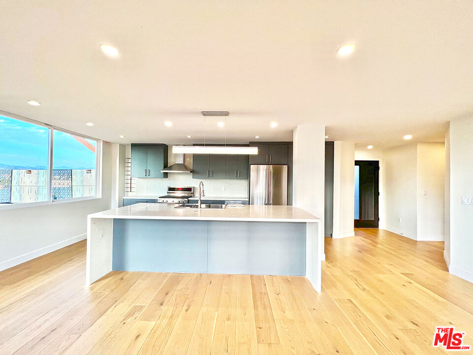 468 South Roxbury Drive, Unit PH Beverly Hills, CA 90212 - Photo 4 of 18 a large kitchen with kitchen island a sink stainless steel appliances and cabinets