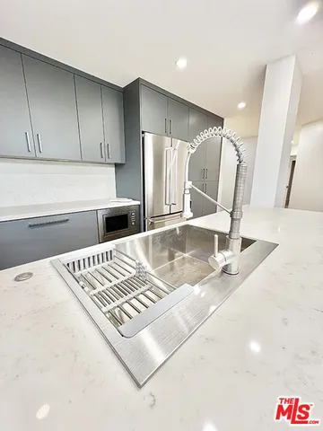 a kitchen with kitchen island a sink a stove and a refrigerator