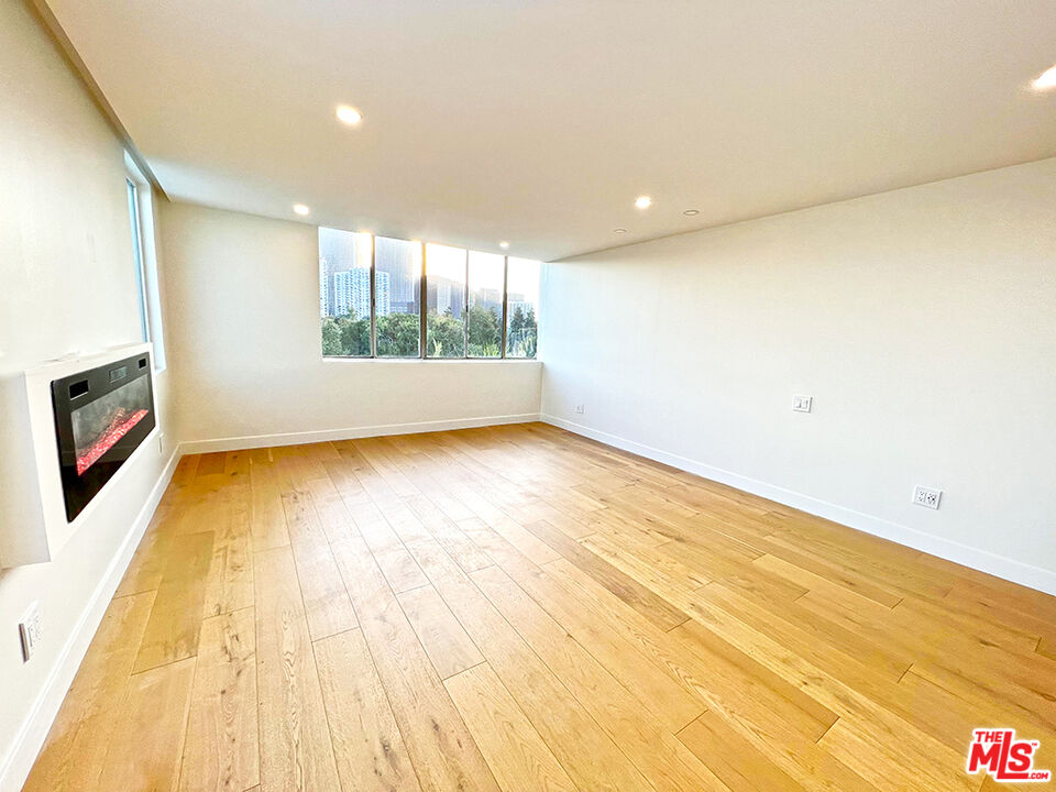 468 South Roxbury Drive, Unit PH Beverly Hills, CA 90212 - Photo 10 of 18 a view of an empty room with wooden floor and a window
