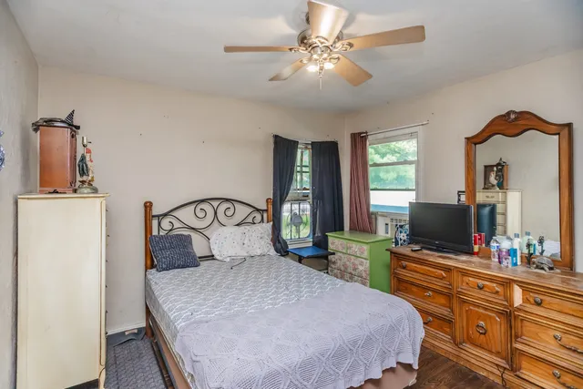 a bedroom with a bed and a flat tv screen on dresser