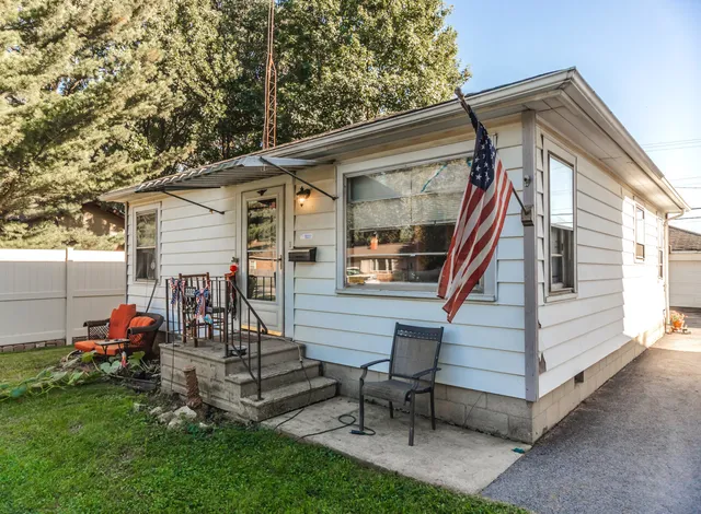 a view of a house with backyard and chairs
