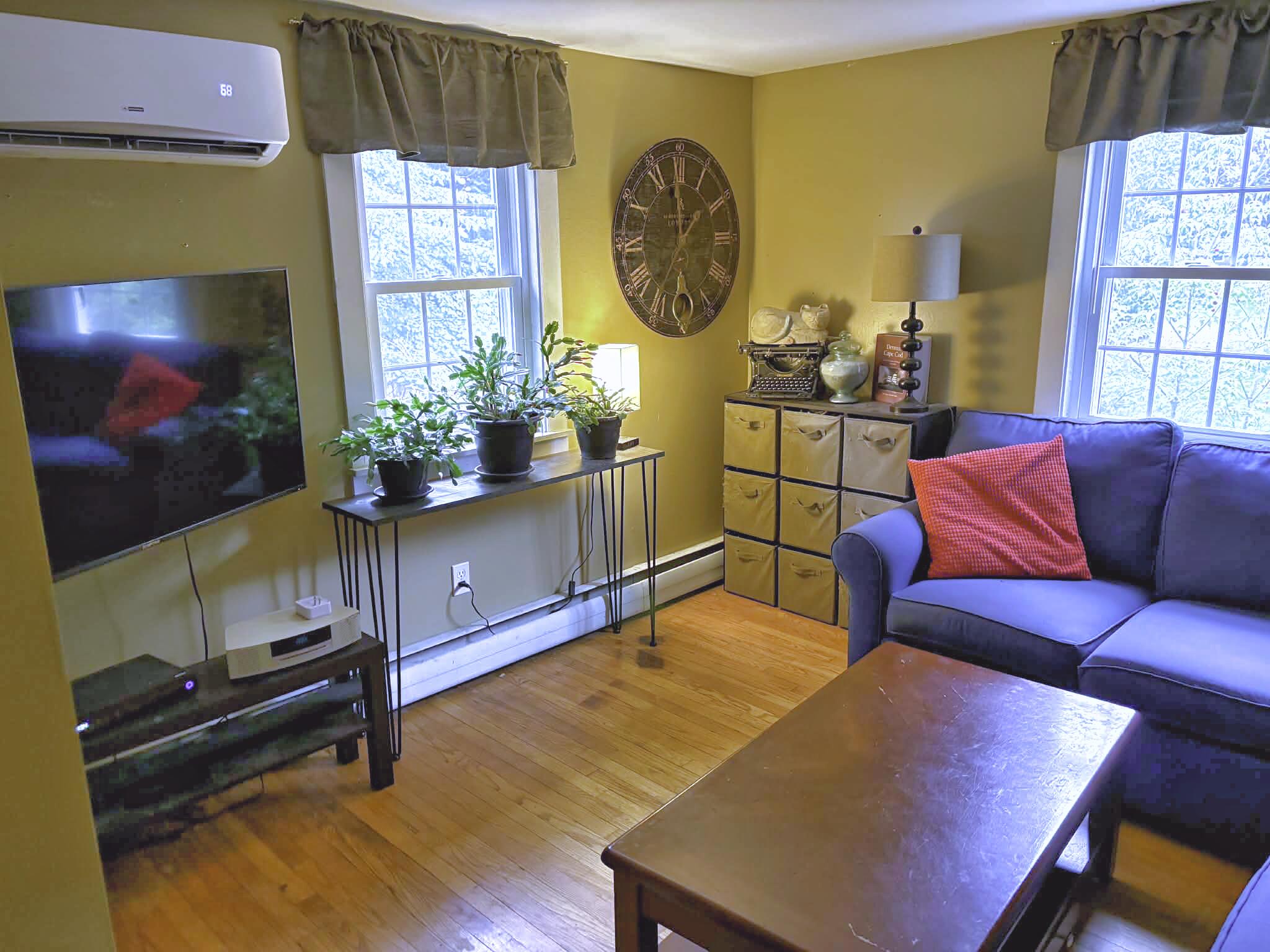 13 Allen Street Harwich, MA 02645 - Photo 13 of 31 a living room with furniture a flat screen tv and wall paintings