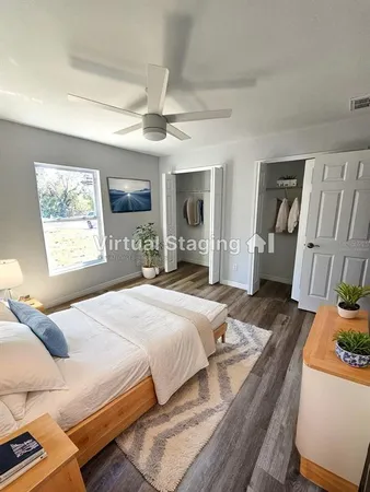 a bedroom with a bed wooden floor and window
