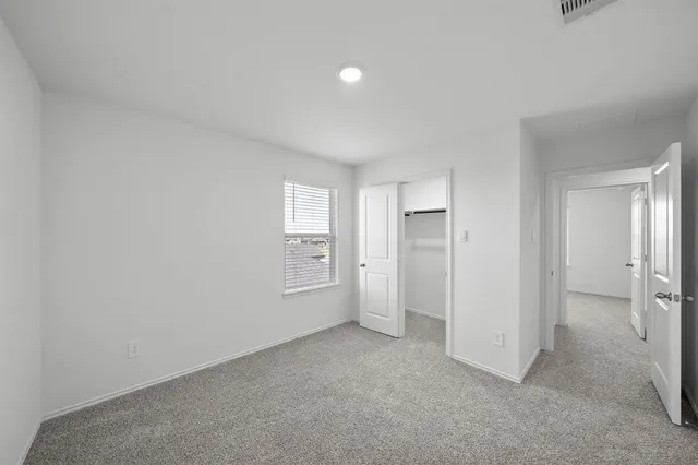 an empty room with windows and closet