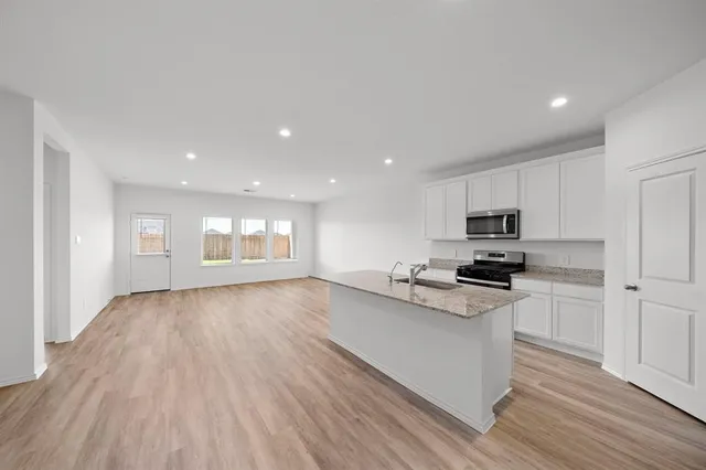 a kitchen with stainless steel appliances a stove a sink and a refrigerator