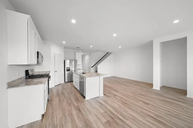 a view of kitchen with wooden floor and electronic appliances