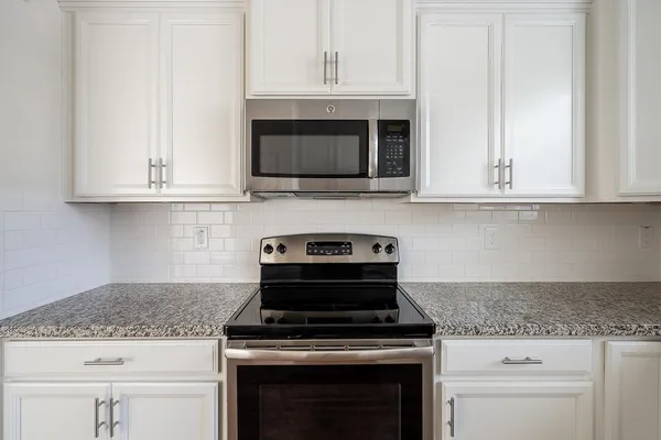 an empty room with wooden floor ceiling fan and windows