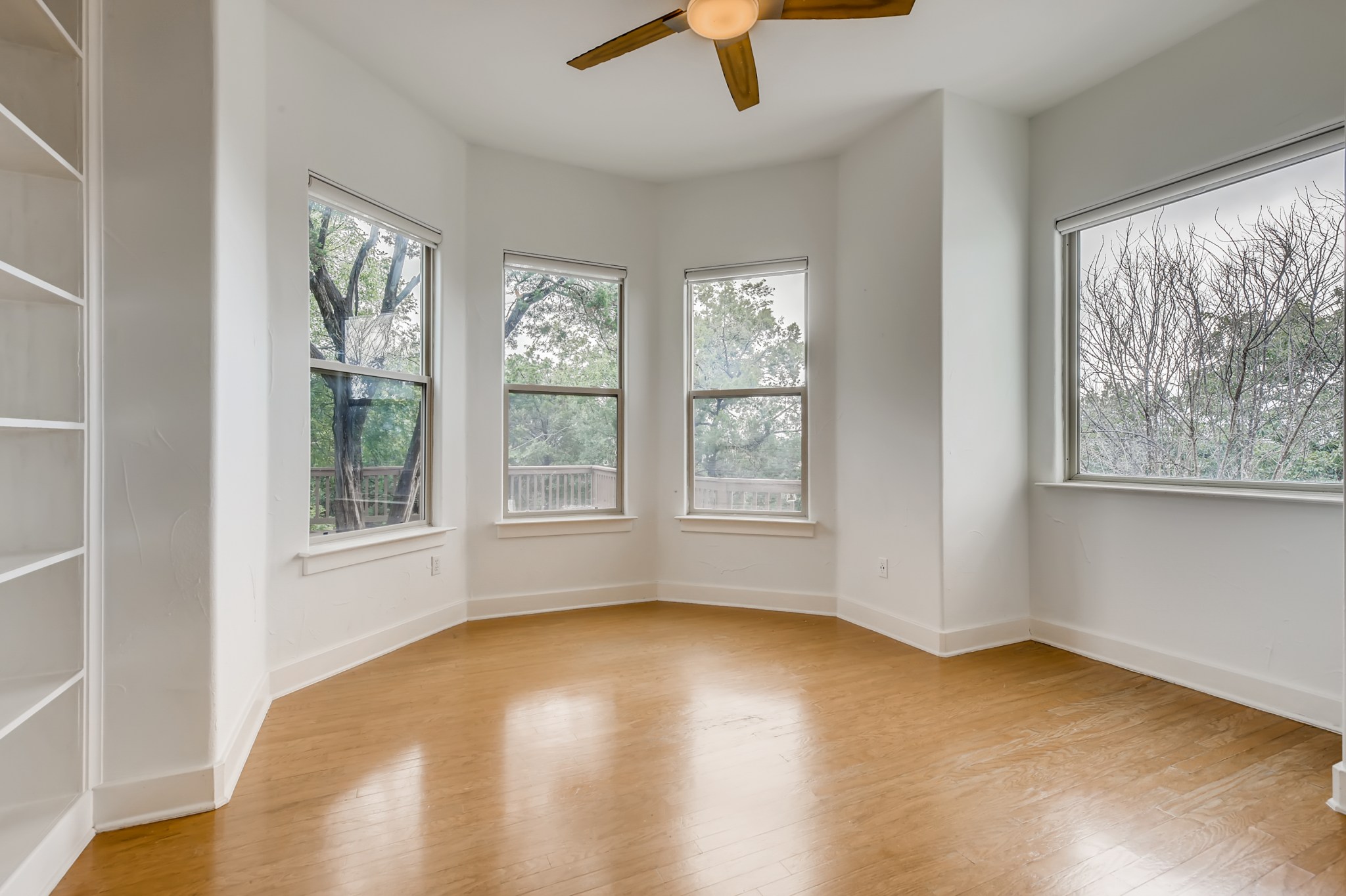 2800 Waymaker Way, Unit 27 Austin, TX 78746 - Photo 4 of 17 Unfurnished room featuring a ceiling fan and light wood-type flooring