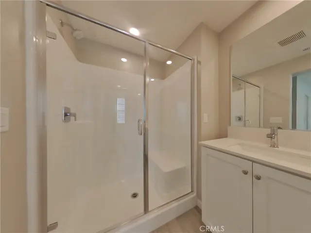 a bathroom with a shower sink vanity and mirror