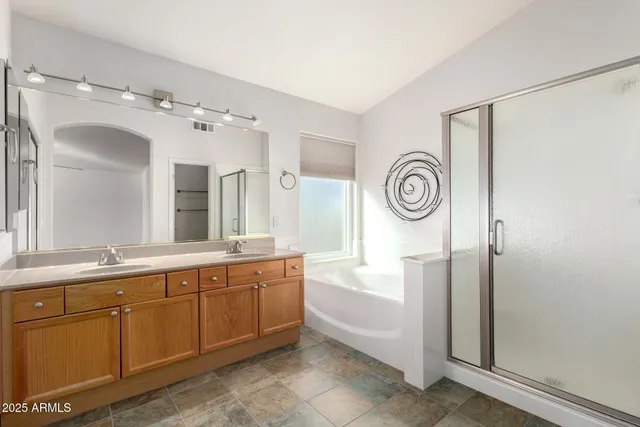 a spacious bathroom with a double vanity sink and a mirror