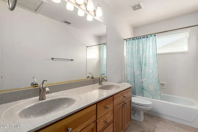 a bathroom with a granite countertop sink a toilet and a large mirror