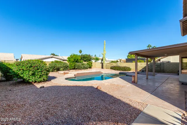 a view of a swimming pool with lawn chairs under an umbrella