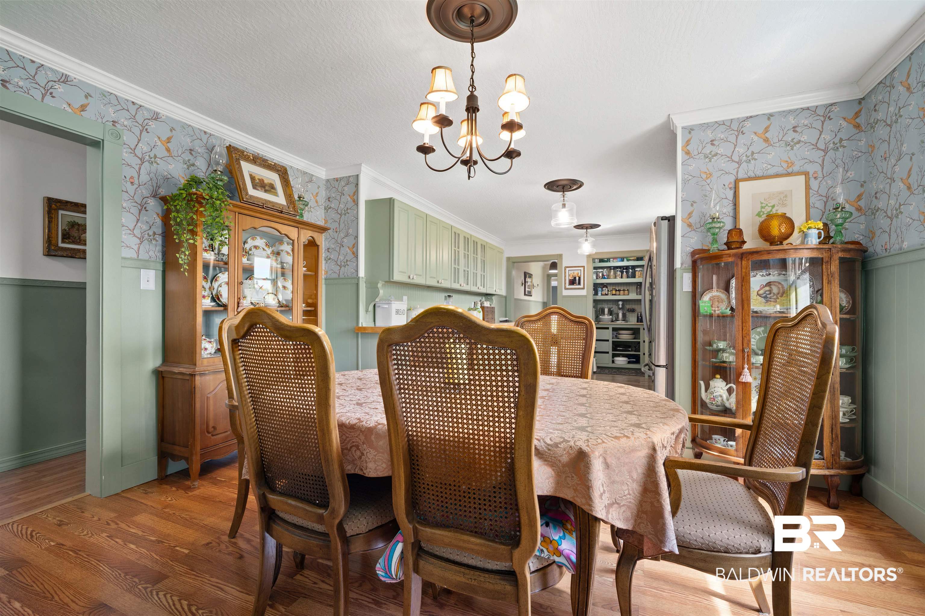 22 Horace Odom Road Millry, AL 36558 - Photo 17 of 39 Dining space with wallpapered walls, a wainscoted wall, ornamental molding, a chandelier, and light wood-type flooring