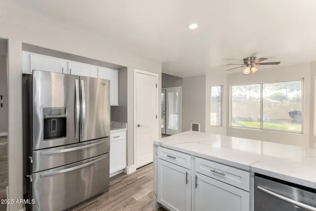 a kitchen with stainless steel appliances a sink and a large window